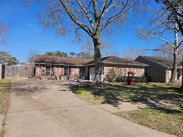 ranch-style house featuring an attached garage, fence, a front lawn, and concrete driveway