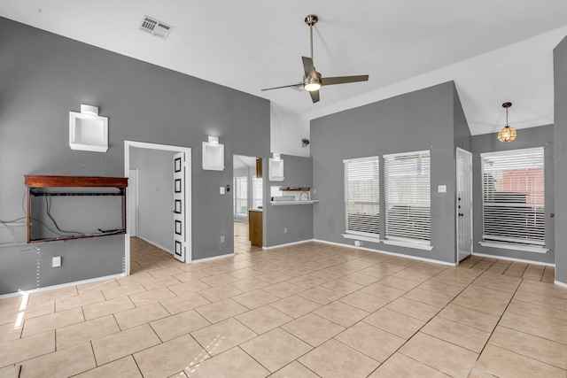 unfurnished living room featuring ceiling fan, high vaulted ceiling, tile patterned flooring, visible vents, and baseboards