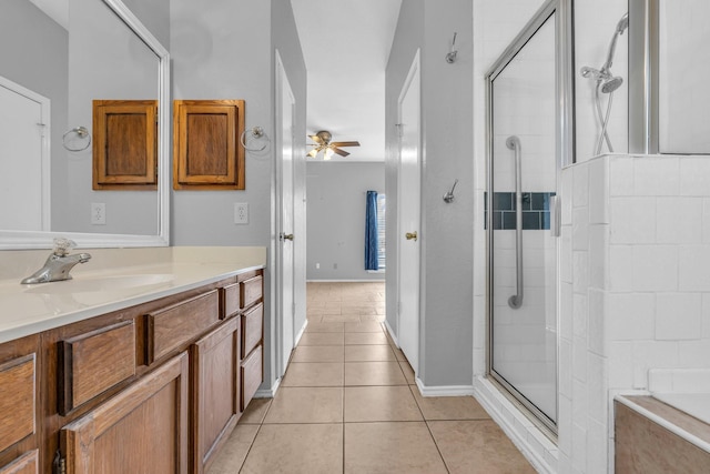 full bath featuring a ceiling fan, tile patterned flooring, tiled shower, and vanity