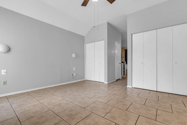 unfurnished bedroom with ceiling fan, light tile patterned floors, two closets, and baseboards