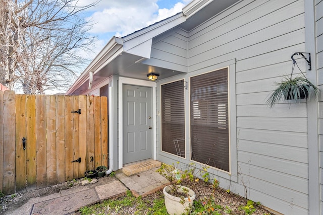 entrance to property featuring fence