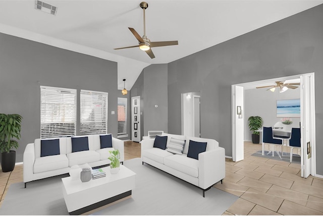 living area with lofted ceiling, ceiling fan, light tile patterned floors, visible vents, and baseboards