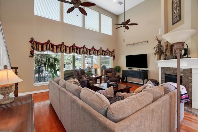 living room with ceiling fan, a healthy amount of sunlight, a fireplace, and wood finished floors