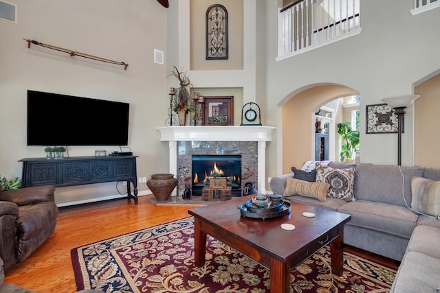 living area featuring a healthy amount of sunlight, visible vents, wood finished floors, and a tile fireplace