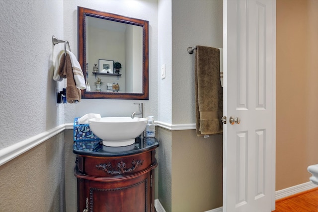 bathroom featuring baseboards, wood finished floors, and vanity