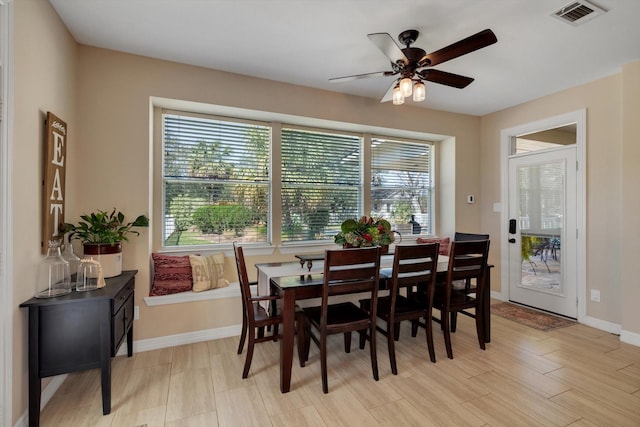 dining room with ceiling fan, light wood-type flooring, visible vents, and baseboards