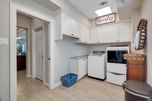 laundry room with separate washer and dryer, cabinet space, visible vents, and baseboards