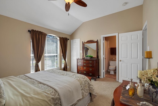 bedroom featuring lofted ceiling, carpet floors, connected bathroom, and a ceiling fan