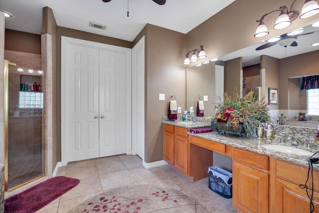 bathroom with ceiling fan, a sink, a shower stall, and visible vents