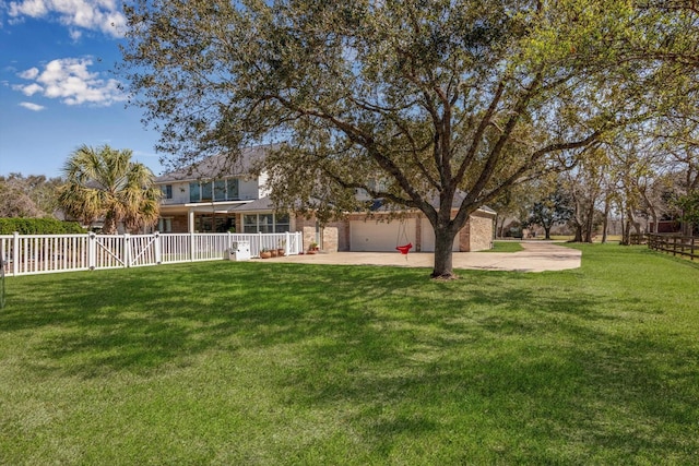 view of yard featuring a patio, a garage, fence, driveway, and a gate