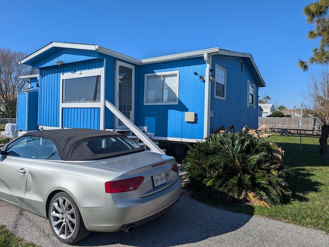 view of front of home with fence and a front lawn