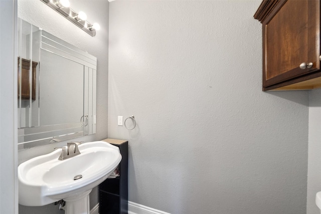 8133 N Fm 565th Rd, Baytown, TX 77523 - bathroom featuring baseboards and a sink