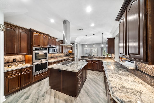 8133 N Fm 565th Rd, Baytown, TX 77523 - kitchen featuring tasteful backsplash, island range hood, stainless steel appliances, light wood-style flooring, and a peninsula