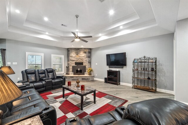 8133 N Fm 565th Rd, Baytown, TX 77523 - living area with a raised ceiling, wood finished floors, baseboards, a fireplace, and ceiling fan