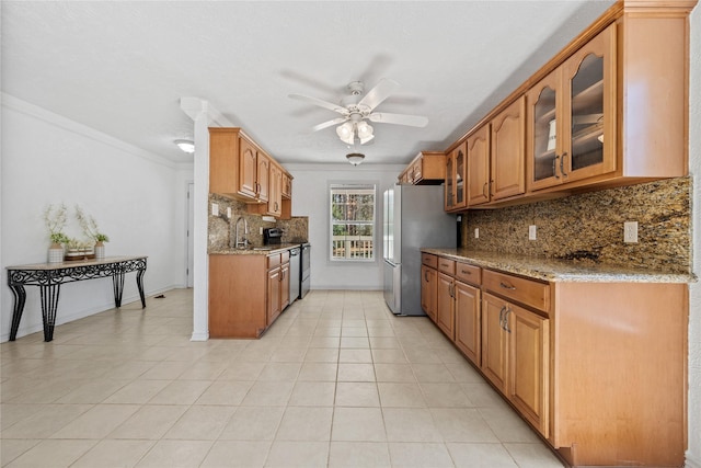 kitchen featuring light stone countertops, ceiling fan, range, and freestanding refrigerator