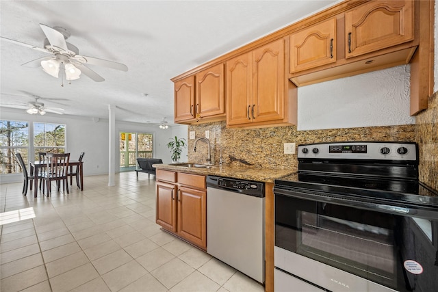 kitchen featuring light tile patterned flooring, appliances with stainless steel finishes, a sink, a ceiling fan, and tasteful backsplash