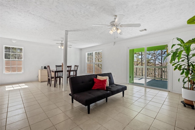 sitting room featuring a wealth of natural light, light tile patterned flooring, and visible vents