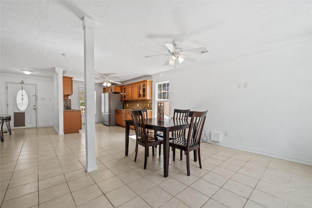 dining space with light tile patterned floors, ceiling fan, baseboards, and a textured ceiling