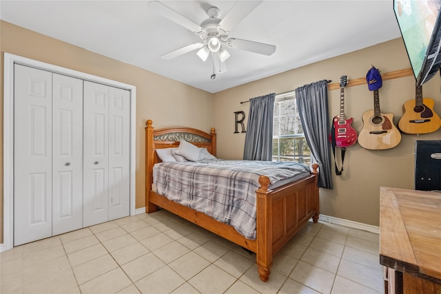 bedroom featuring a closet, light tile patterned flooring, a ceiling fan, and baseboards