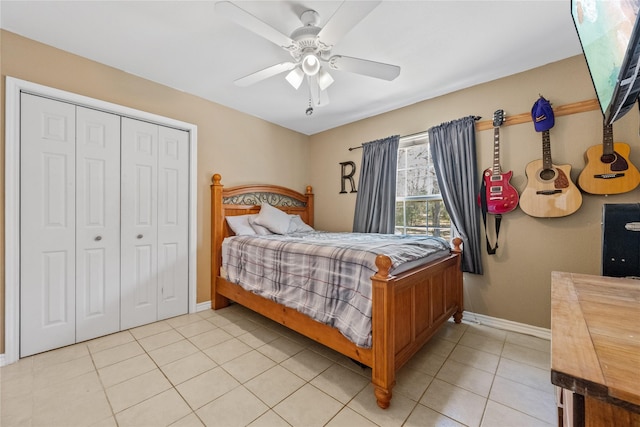 bedroom with light tile patterned flooring, baseboards, a ceiling fan, and a closet