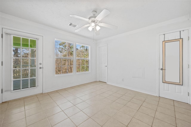 spare room featuring baseboards, a ceiling fan, visible vents, and crown molding