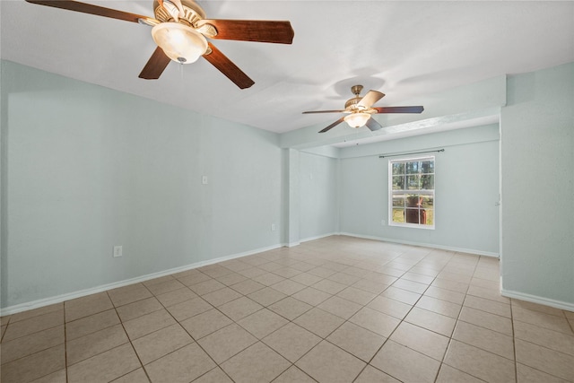 spare room with a ceiling fan, baseboards, and light tile patterned flooring