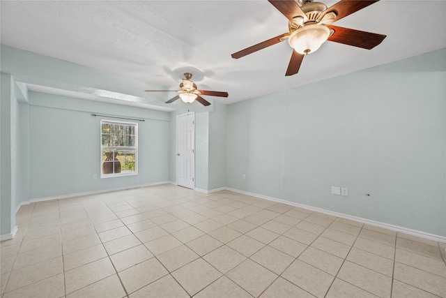 unfurnished room featuring light tile patterned floors, baseboards, and ceiling fan