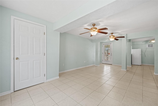 spare room with light tile patterned floors, a ceiling fan, and baseboards