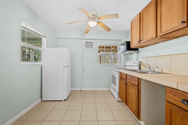 kitchen featuring white appliances, baseboards, brown cabinetry, and light countertops
