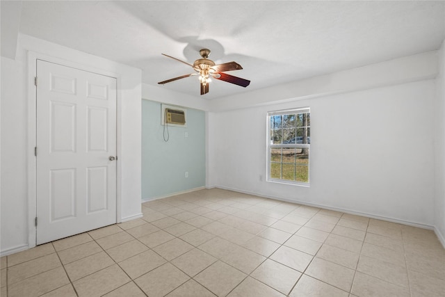 empty room featuring light tile patterned floors, baseboards, a ceiling fan, and a wall mounted air conditioner