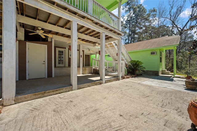 view of patio with ceiling fan and stairway