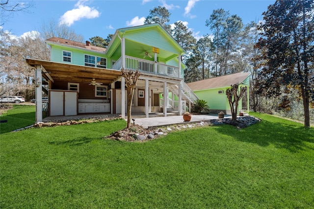 back of property with a yard, a patio area, ceiling fan, and stairs