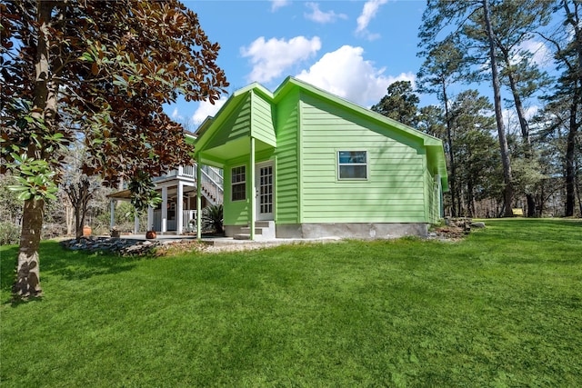 rear view of property featuring entry steps, a yard, and a patio