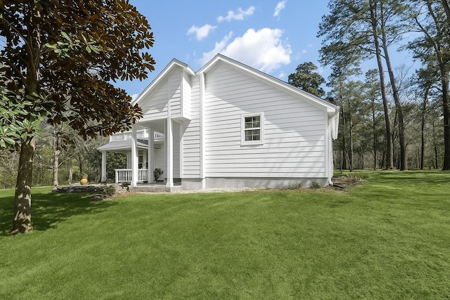 rear view of property featuring a porch and a yard