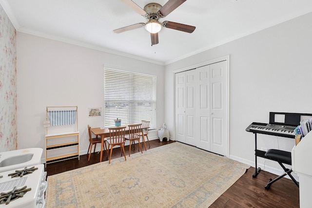 home office featuring ornamental molding, a ceiling fan, baseboards, and wood finished floors