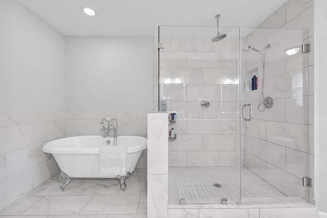 bathroom with a stall shower, a soaking tub, and tile walls