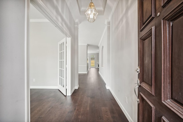 entryway with dark wood-style floors, ornamental molding, a chandelier, and baseboards