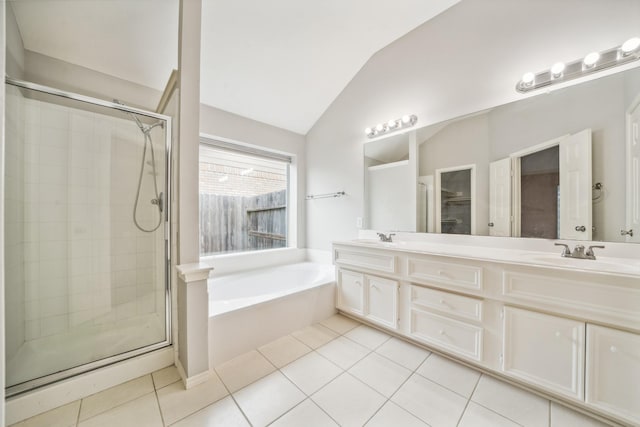 full bath with vaulted ceiling, a shower stall, a sink, and tile patterned floors