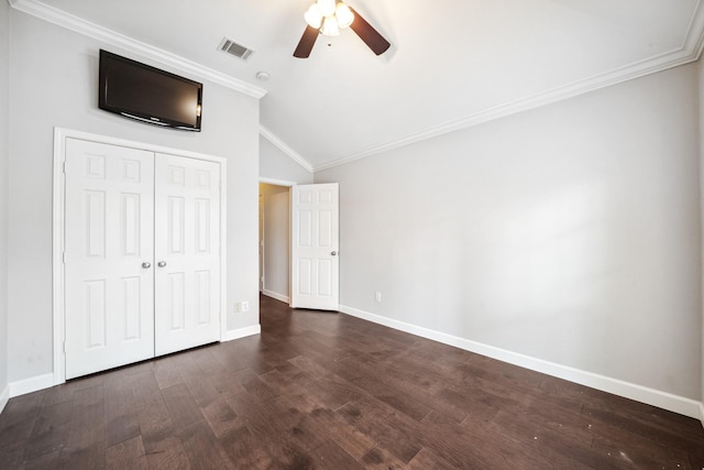 unfurnished bedroom featuring baseboards, visible vents, dark wood finished floors, lofted ceiling, and crown molding