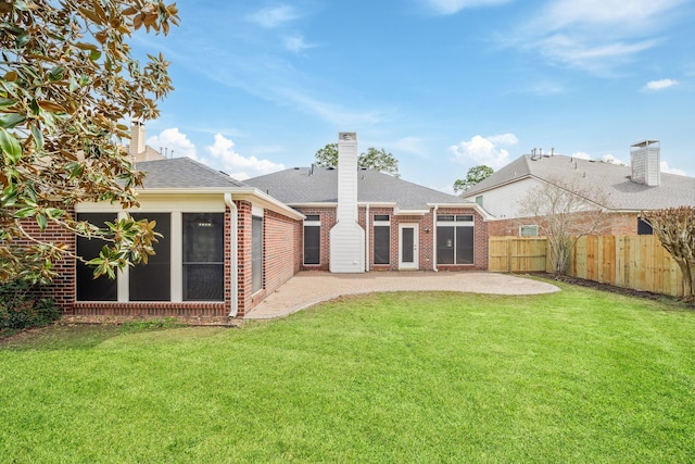 rear view of house featuring fence private yard, a patio area, brick siding, and a yard