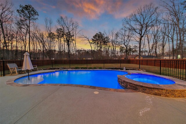 view of pool with a fenced backyard, a pool with connected hot tub, and a patio