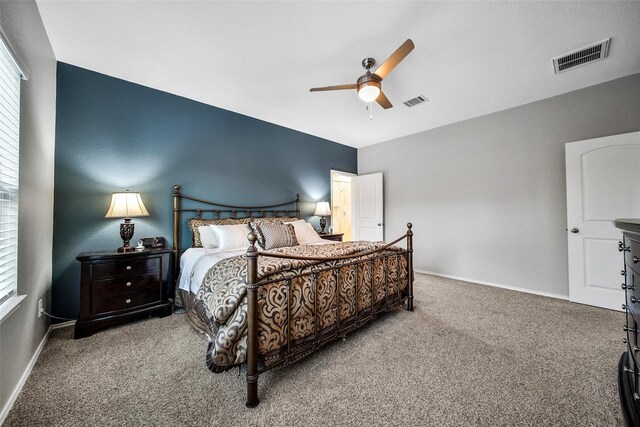 carpeted bedroom featuring visible vents, ceiling fan, and baseboards