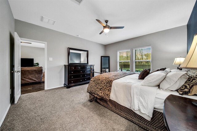 carpeted bedroom with visible vents, a ceiling fan, and baseboards