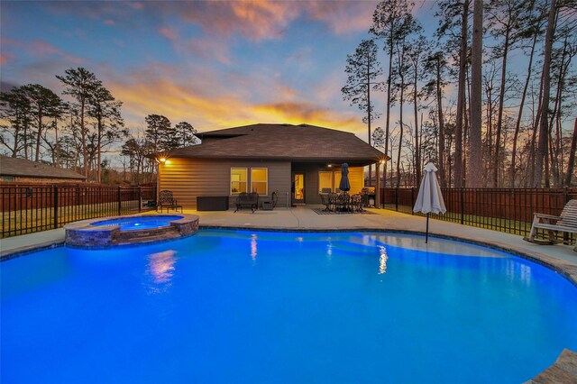 view of swimming pool featuring a patio area, a fenced backyard, and a pool with connected hot tub