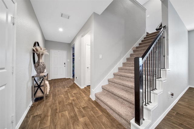 entryway featuring stairway, baseboards, visible vents, and wood finished floors