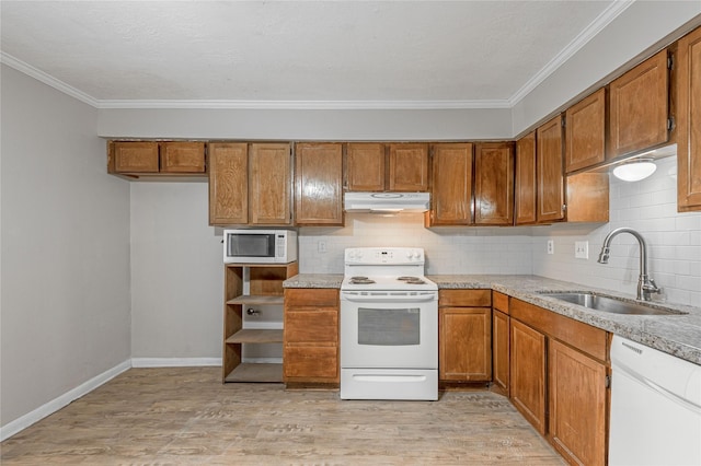 kitchen featuring white appliances, brown cabinets, a sink, and under cabinet range hood