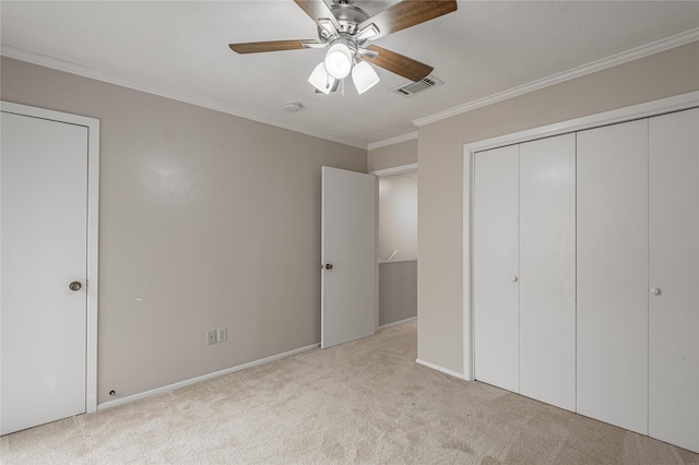 unfurnished bedroom featuring carpet, crown molding, a closet, visible vents, and a ceiling fan