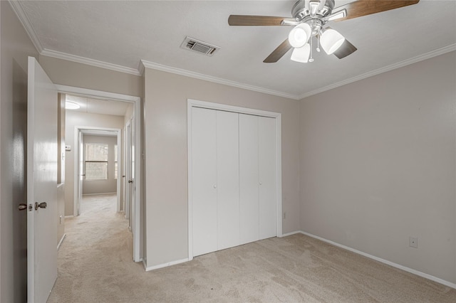 unfurnished bedroom with visible vents, light carpet, attic access, and crown molding