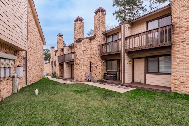 view of property's community featuring a yard and a patio