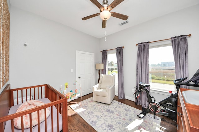 bedroom featuring a ceiling fan, baseboards, visible vents, and wood finished floors